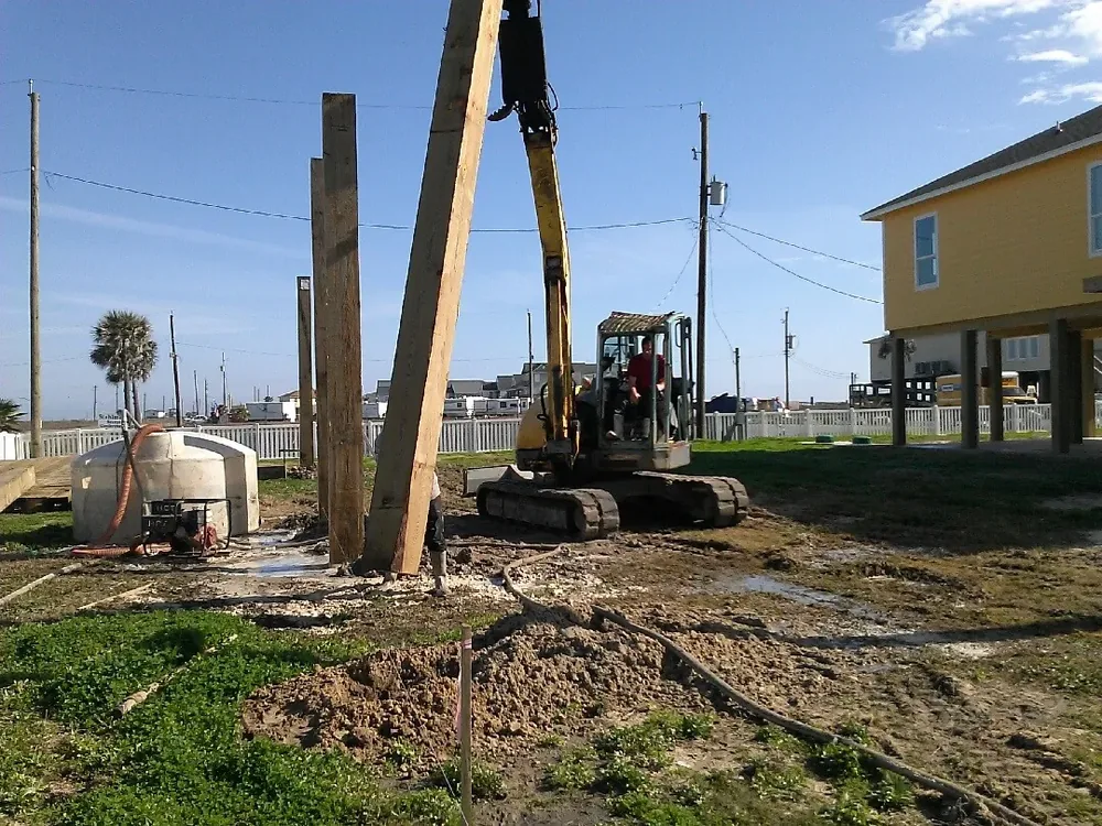 Excavator setting deep support piers at a Gulf Coast foundation project